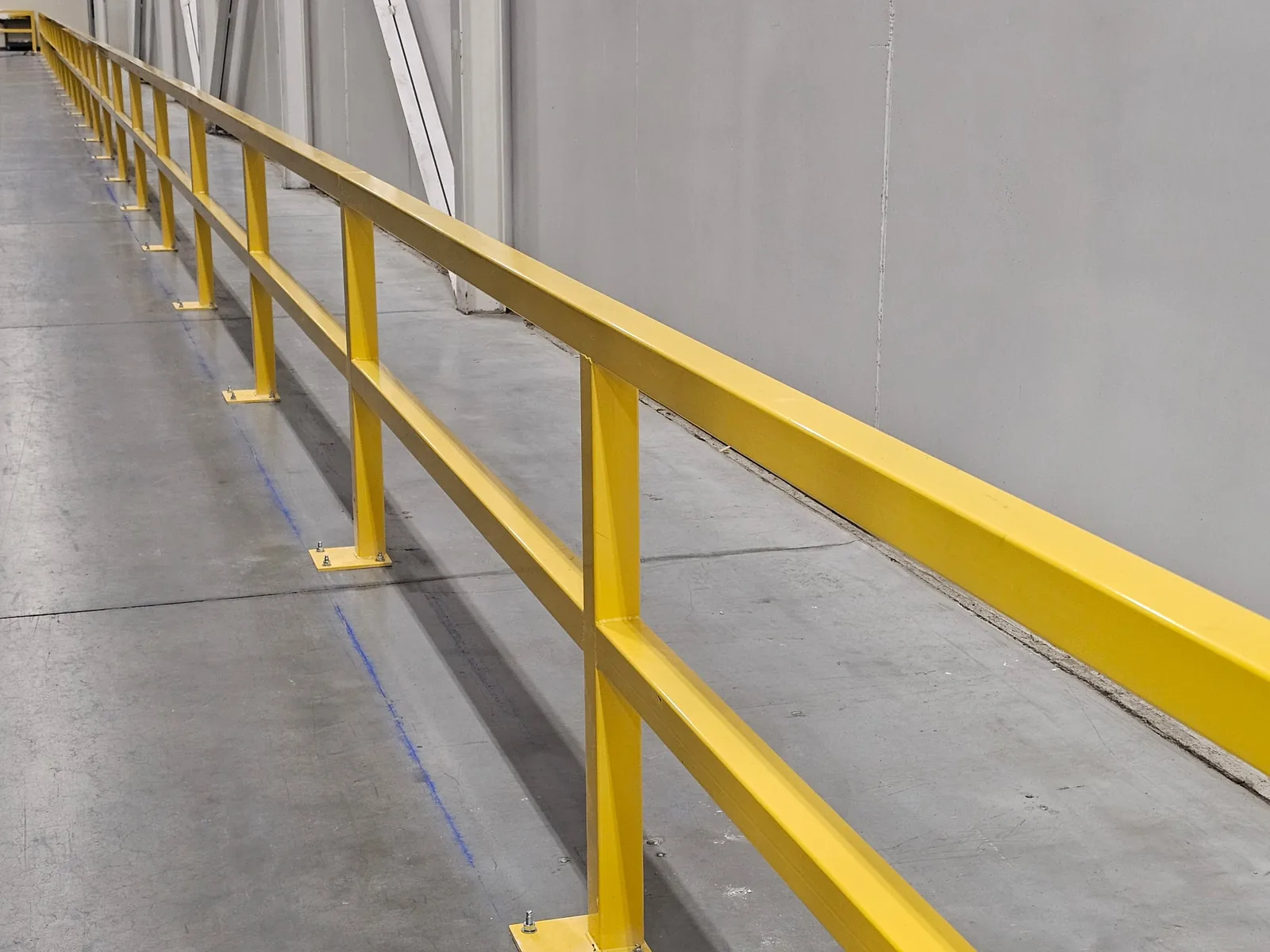 Close view of safety barrier posts, rails and base plates in a Markham warehouse