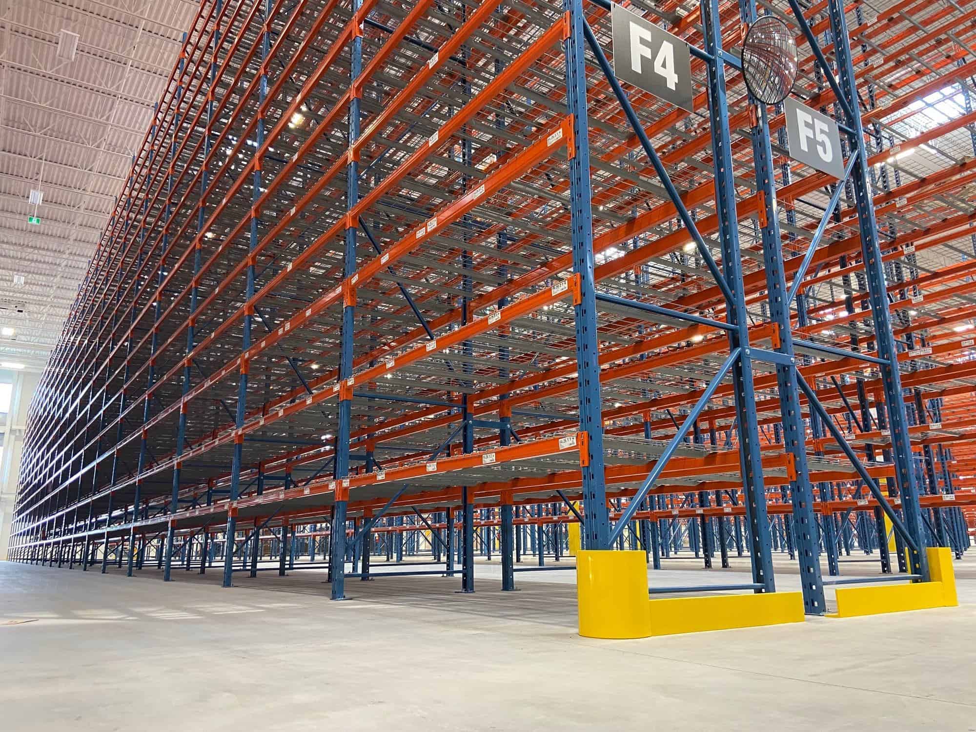 Tall pallet racking aisles with yellow end-of-aisle frame guards