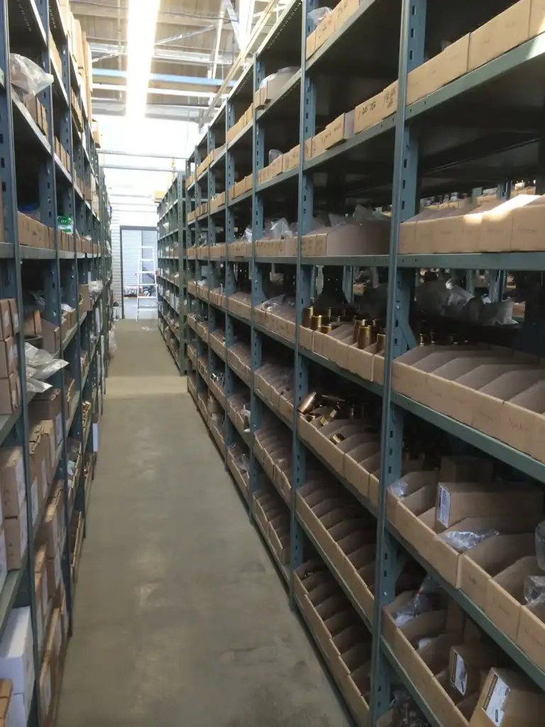 System 200 steel shelving holding open bin boxes of small parts