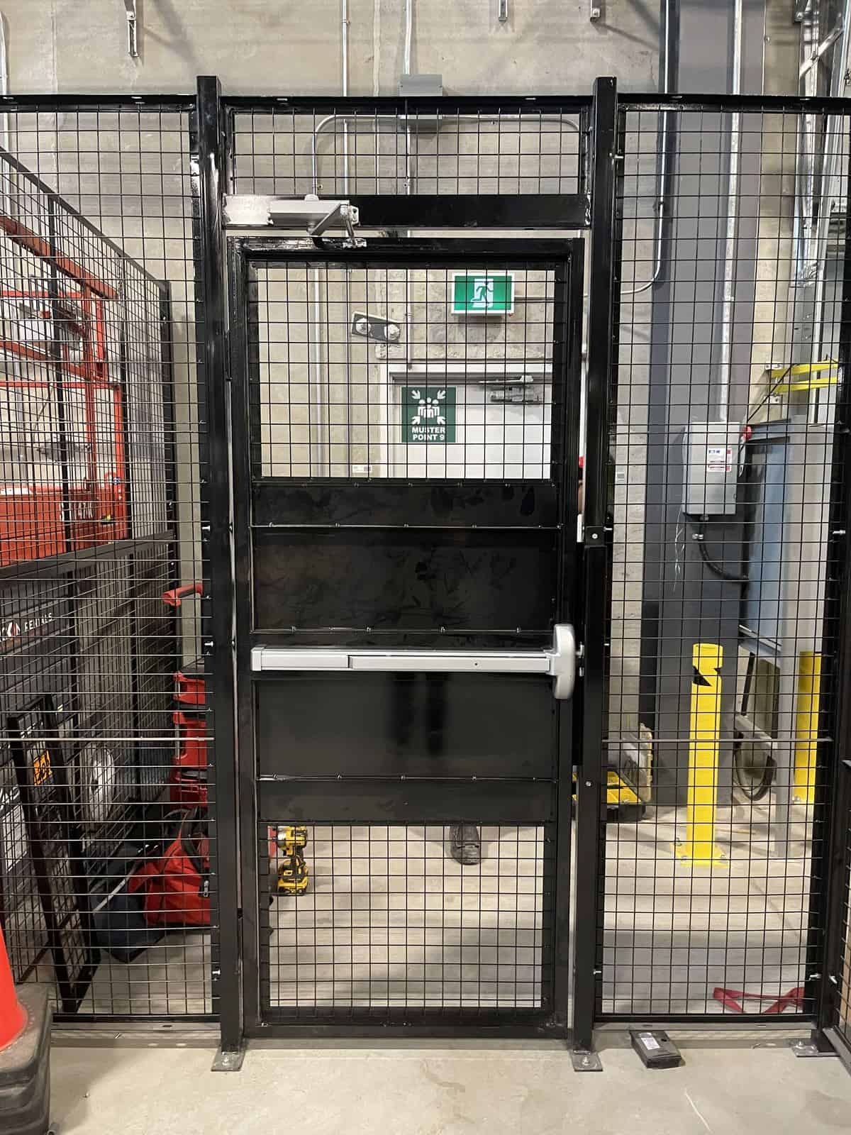 Wire mesh partition door with push bar exit hardware