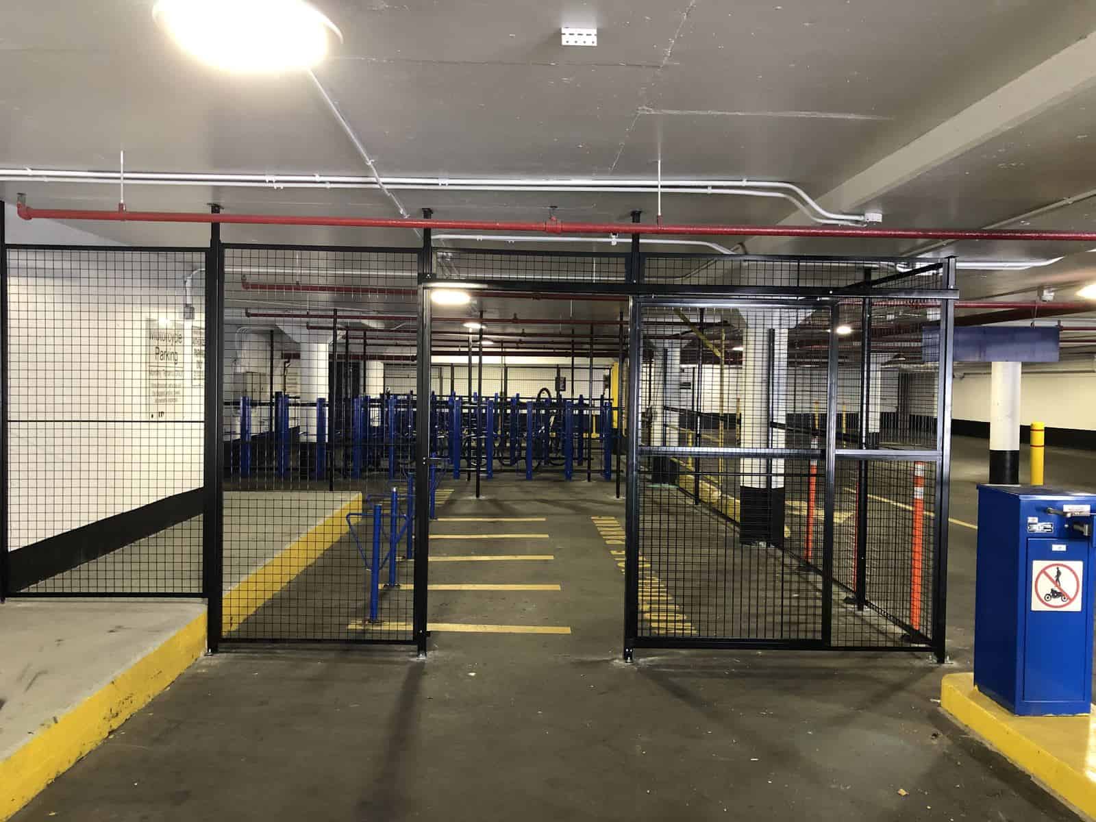 Black wire mesh partition with swing gates in an underground parking garage