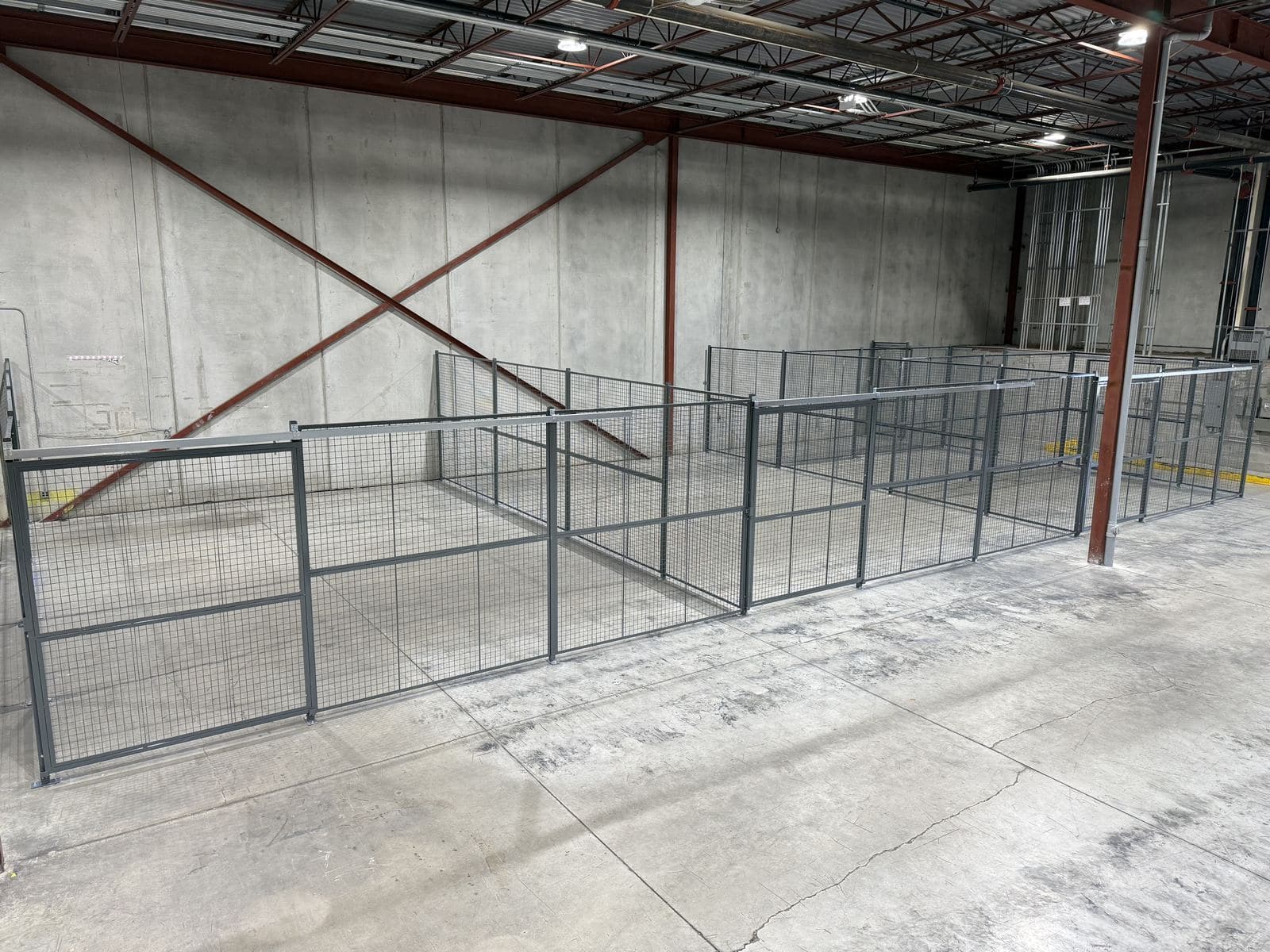 Wire mesh partitions creating a secure area in a warehouse