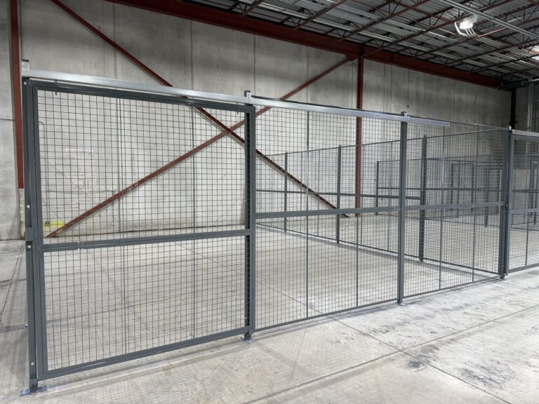 Grey wire mesh partition lock-up with sliding gate in a warehouse