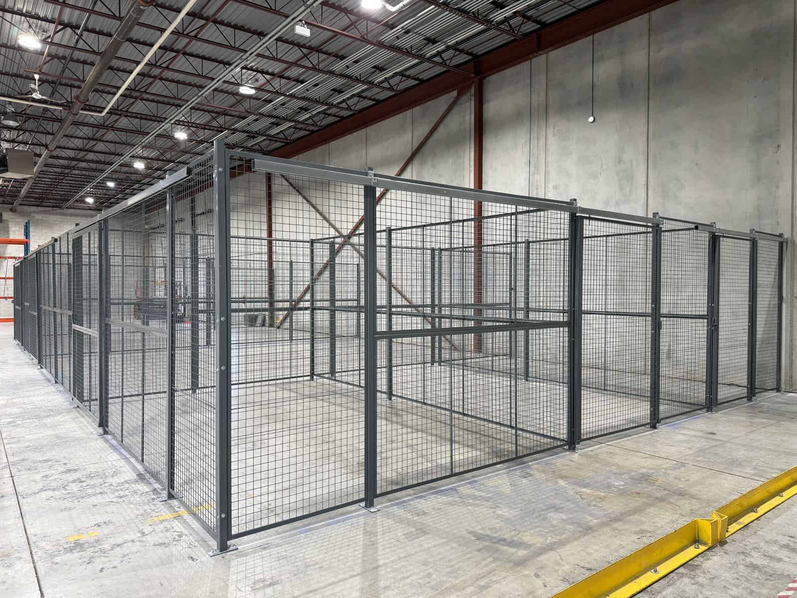 Long run of wire mesh partition storage cages in a warehouse