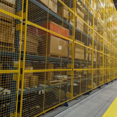 Yellow wire mesh guards along a long run of racking