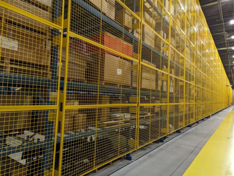 Yellow wire mesh guards along a long run of racking