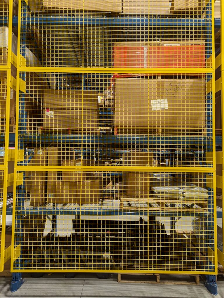 Yellow wire mesh guard panel on a rack bay